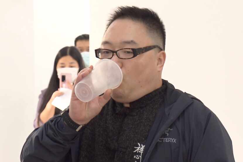 En esta foto tomada de un video publicado por Shanghai Media Group, un hombre inhala la...