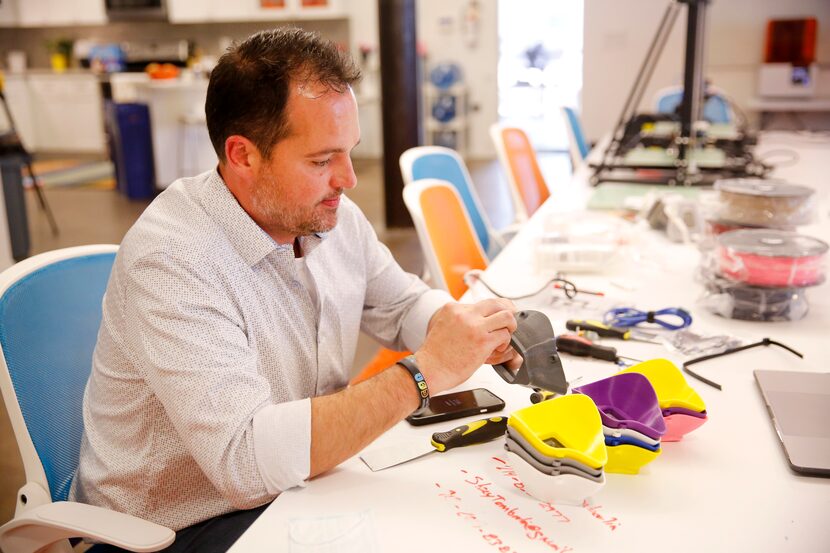 CEO Matt O'Brien sands down a 3-D printed, reusable respiratory mask at Unique Software...