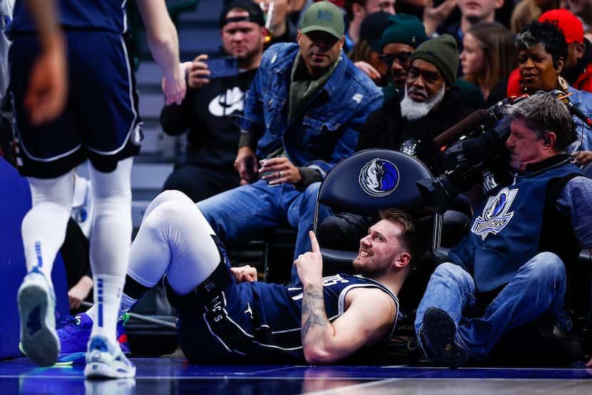 Dallas Mavericks guard Luka Doncic, center bottom, reacts after drawing a foul during the...