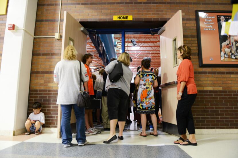 Rockwall High School's incoming freshmen and their parents crowd around the entrance to the...