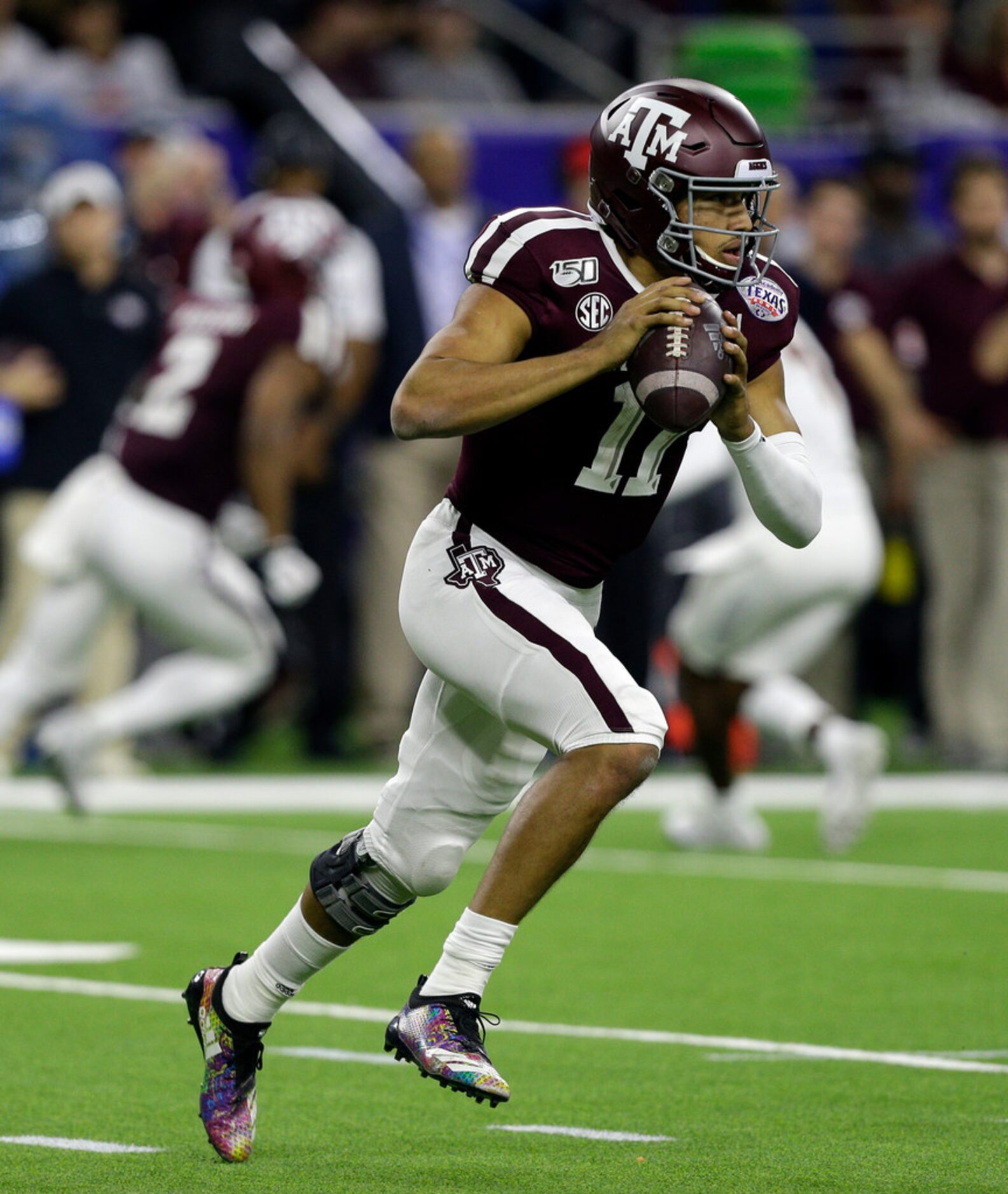 HOUSTON, TEXAS - DECEMBER 27: Kellen Mond #11 of the Texas A&M Aggies scrambles out of the...