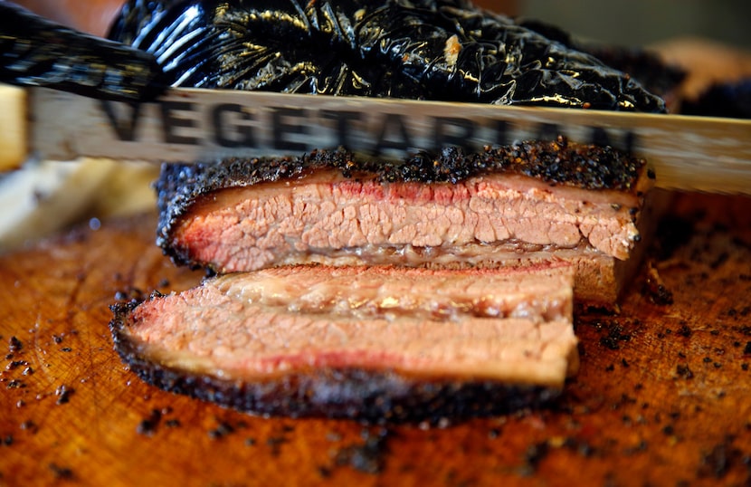 Panther City BBQ co-pitmasters Ernie Morales and Chris Magallanes cut brisket with a blade...