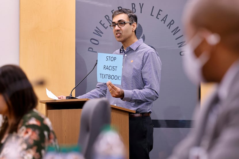 Rajesh Versa, a parent of two kids in the district, holds a sign up to board members as he...
