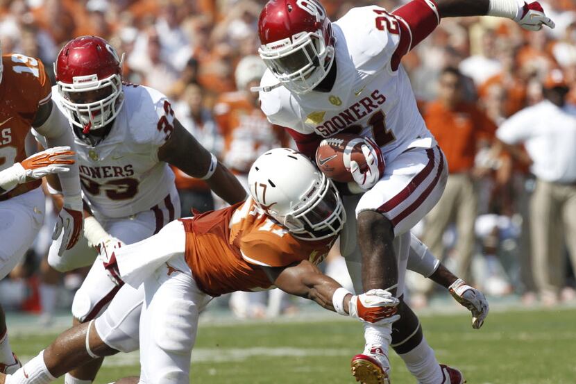 Texas Longhorns safety Adrian Phillips (17) tackles Oklahoma Sooners running back Keith Ford...