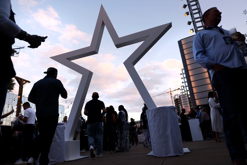 Dallas Cowboys fans hang out during a NFL draft party on the Ford Center plaza at The Star...