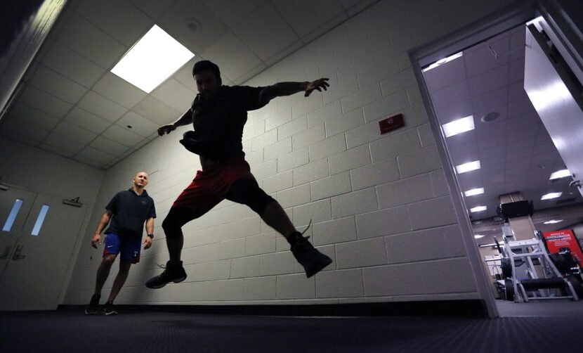 Texas Rangers relief pitcher Matt Bush works on his conditioning in a hallway by the indoor...