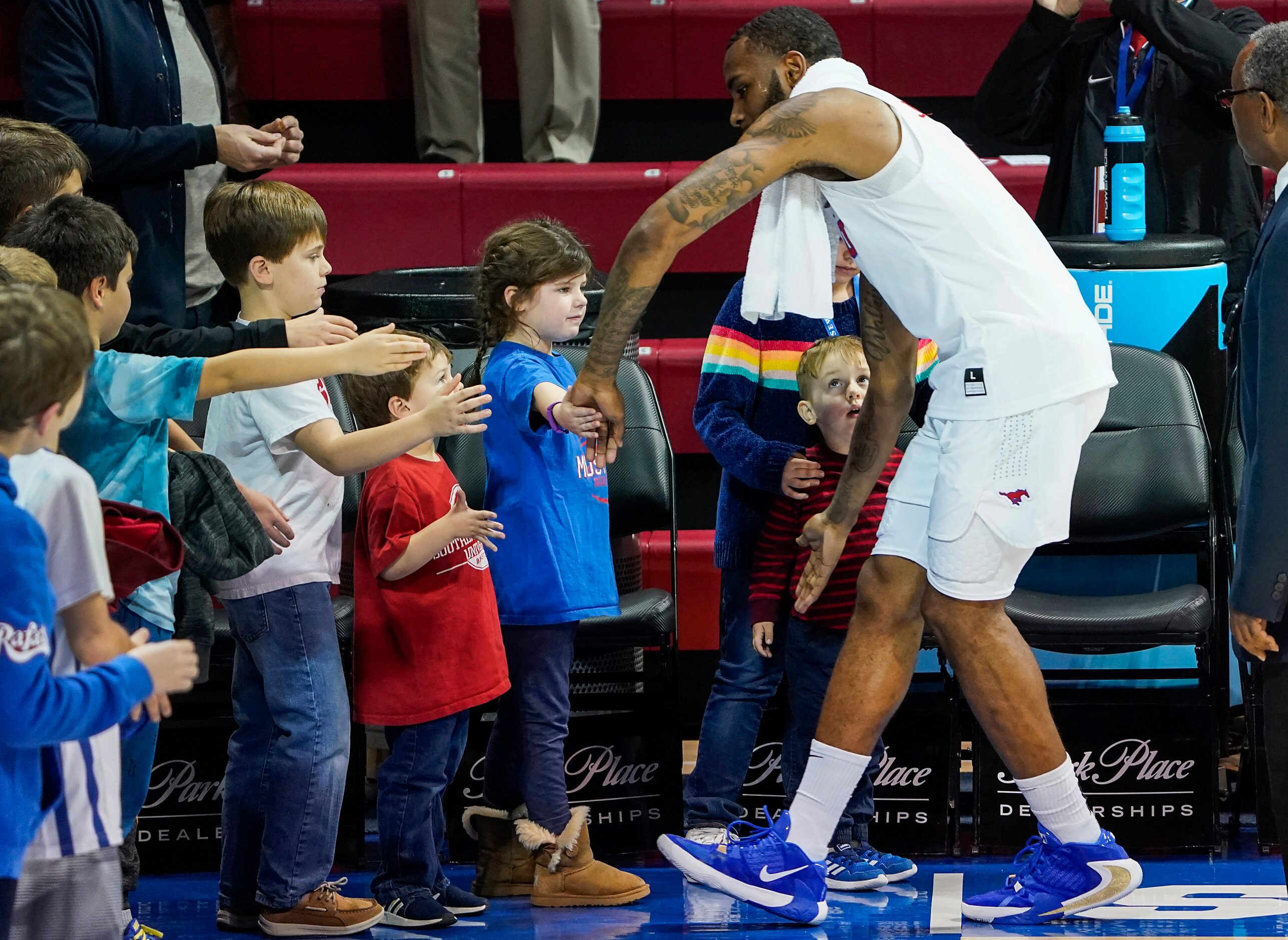 SMU guard Tyson Jolly high fives young fans after a victory over East Carolina in an NCAA...