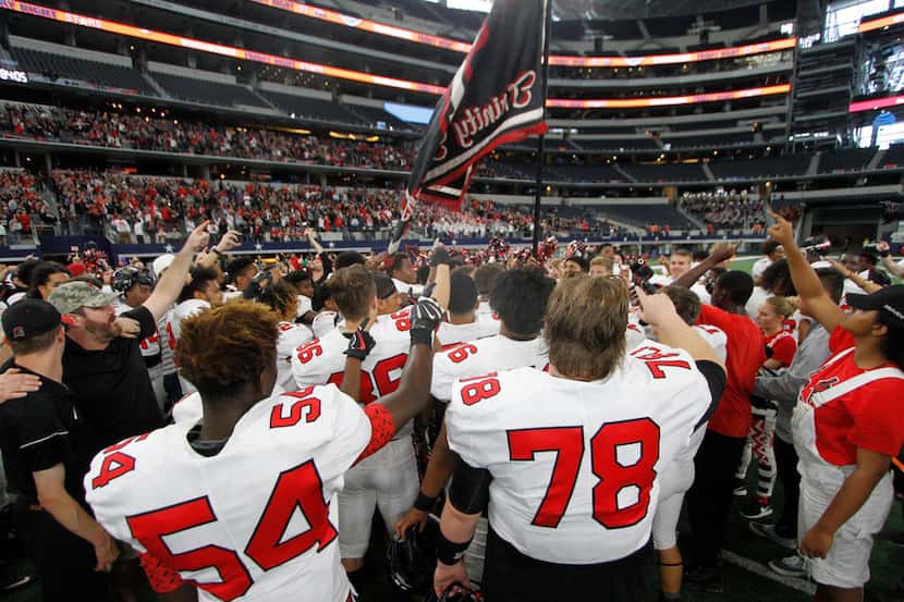 Members of the Euless Trinity Trojans wave their flag during the playing of Trinity's school...