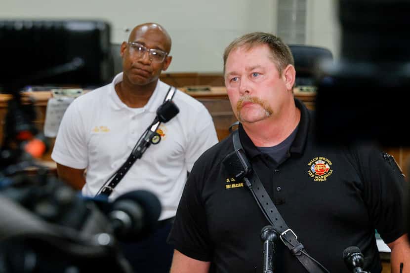 Balch Springs Fire Marshal Sean Davis (right) listens to a question from a reporter...