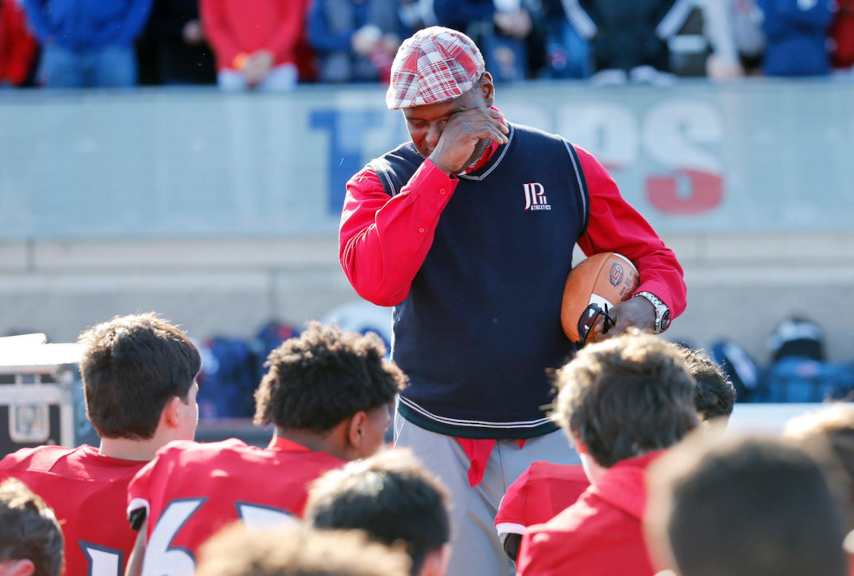 Plano John Paul II's head coach George Teague wipes away tears as he talks to his players...