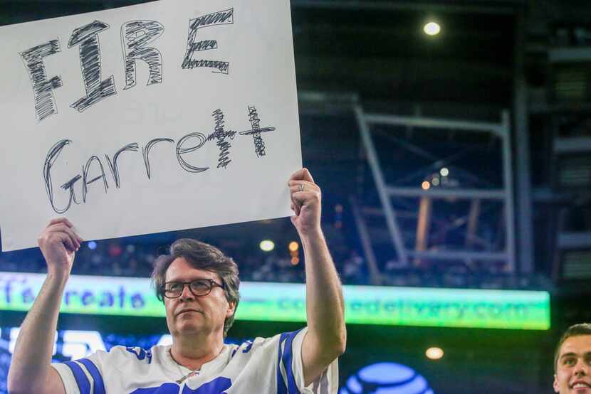 A fan holds a sign suggesting the firing of Dallas Cowboys head coach Jason Garrett during...