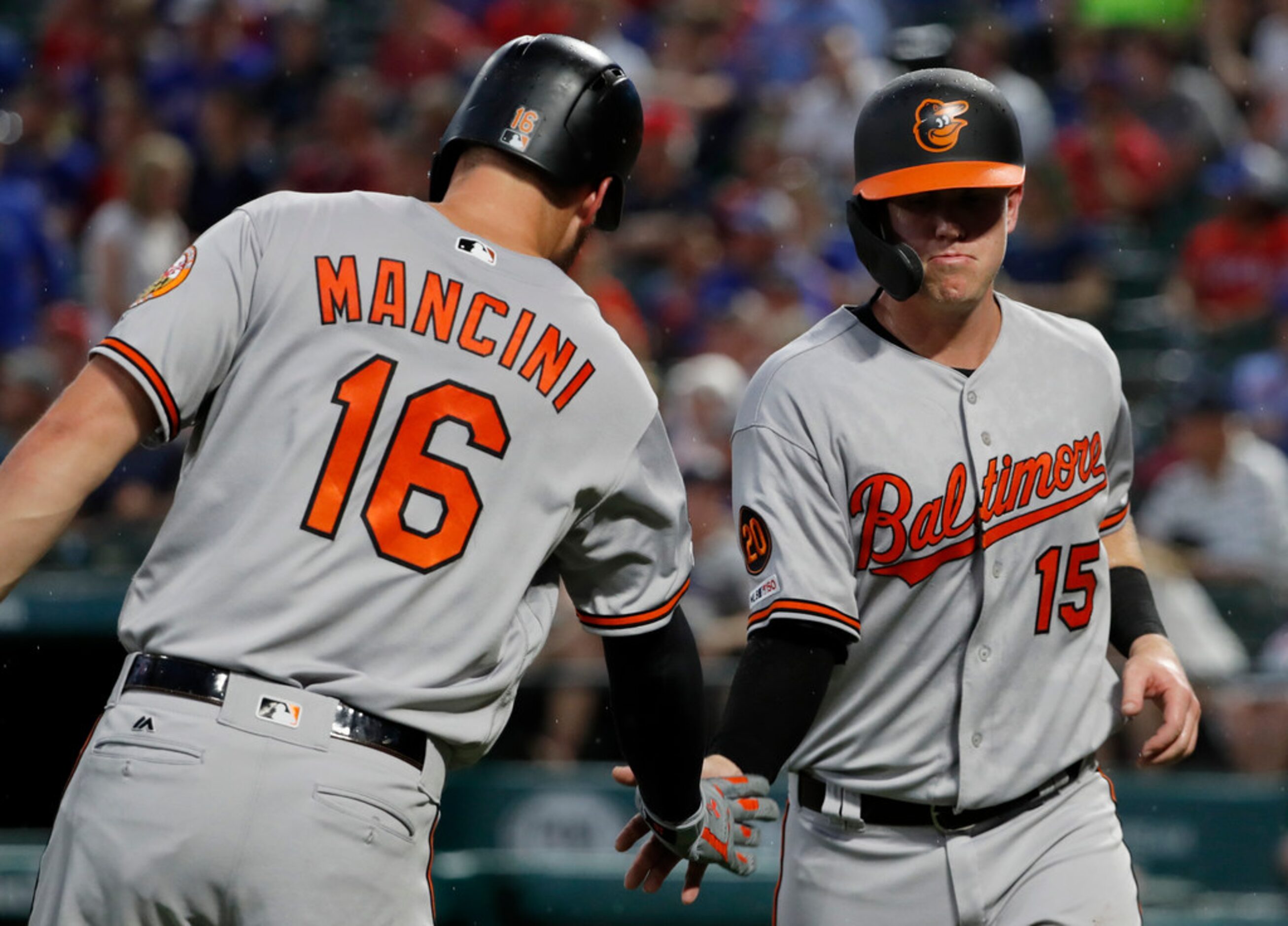 Baltimore Orioles' Trey Mancini congratulates Chance Sisco, who scored on a Stevie Wilkerson...