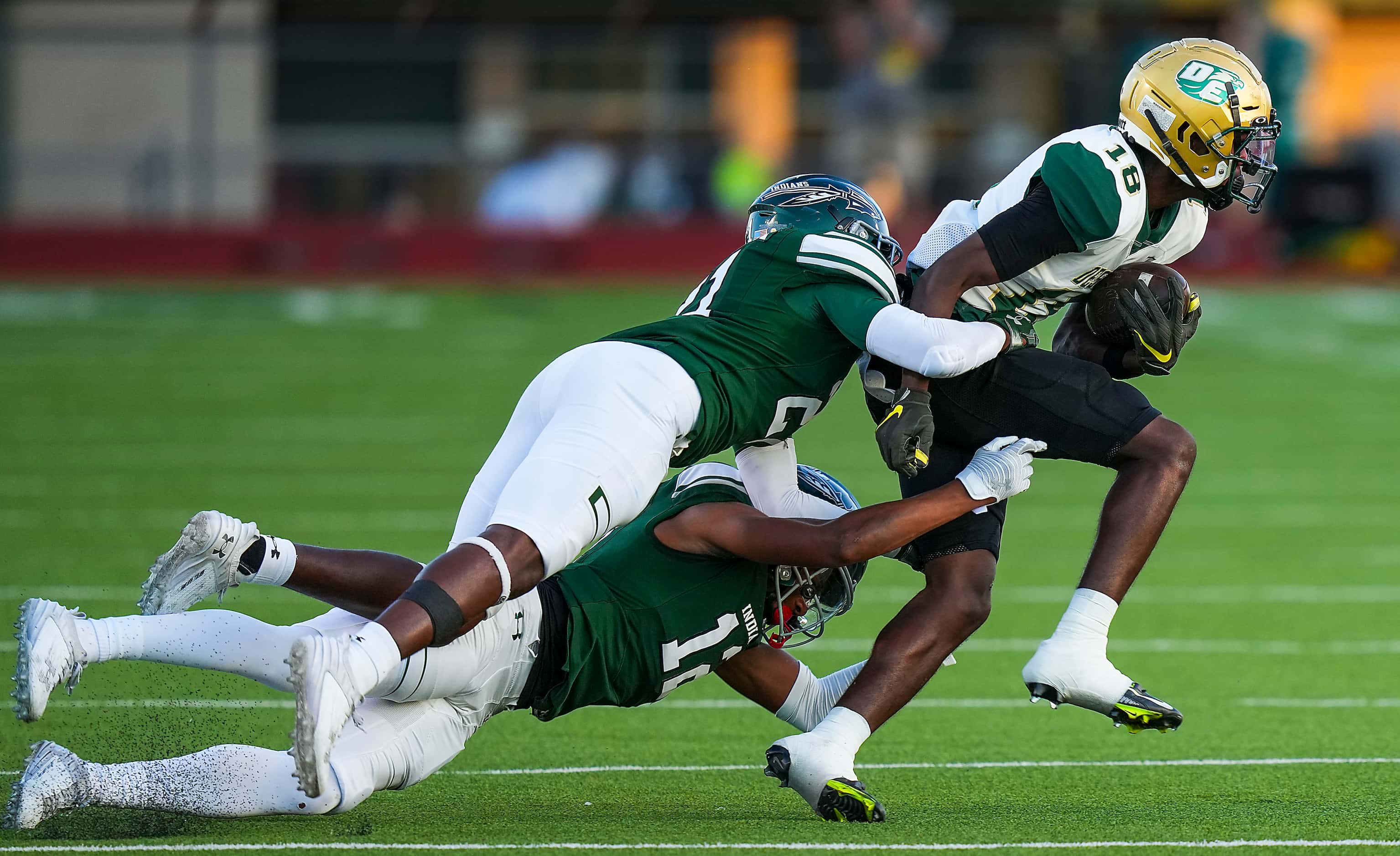 DeSoto  wide receiver Ethan Feaster (18) is brought down by Waxahachie linebacker Da'Mrion...