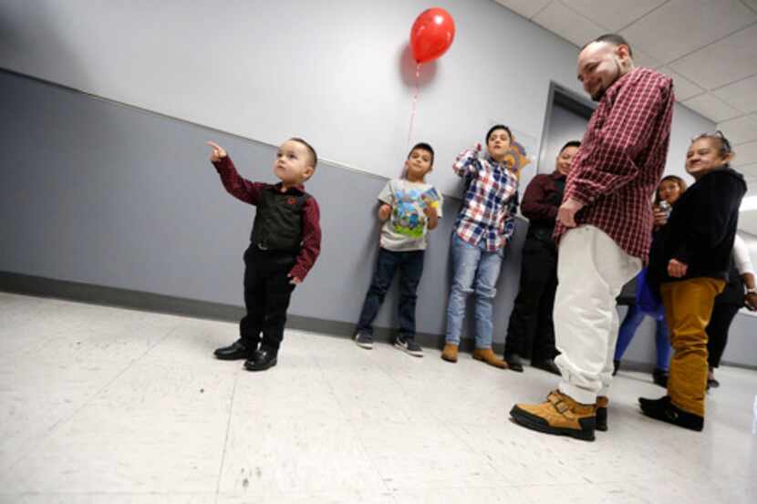 King Romero, de 2 años, señala la sala del tribunal antes de ser adoptado durante el Día...