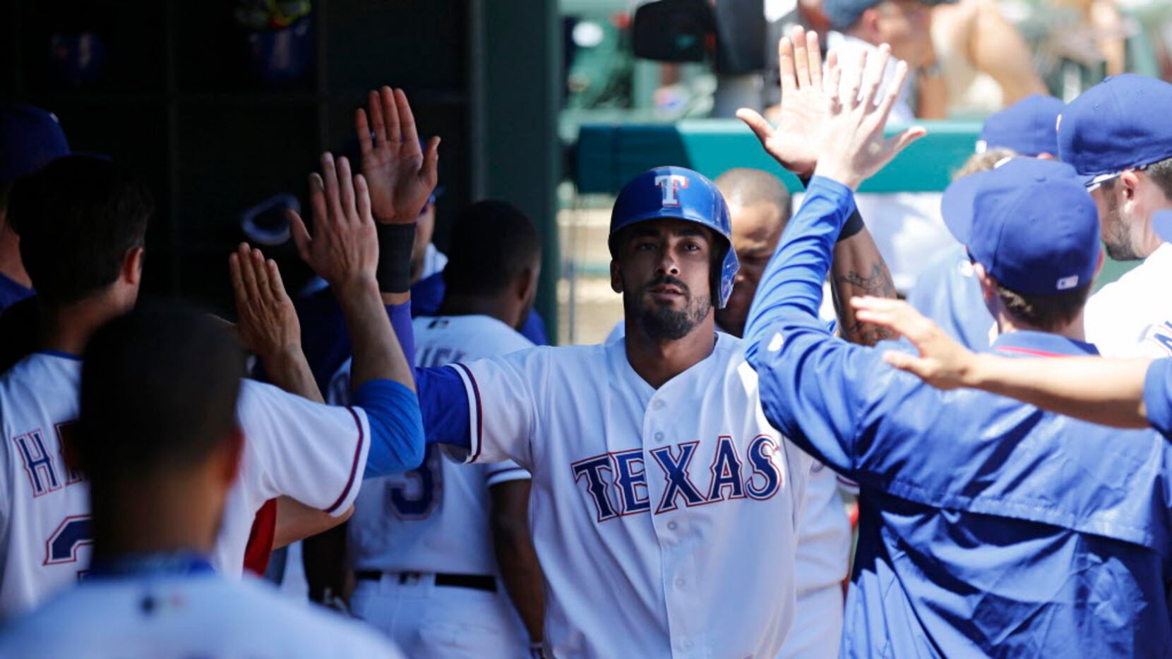 Texas Rangers outfielder Ian Desmond (20) is congratulated by teammates after scoring a run...