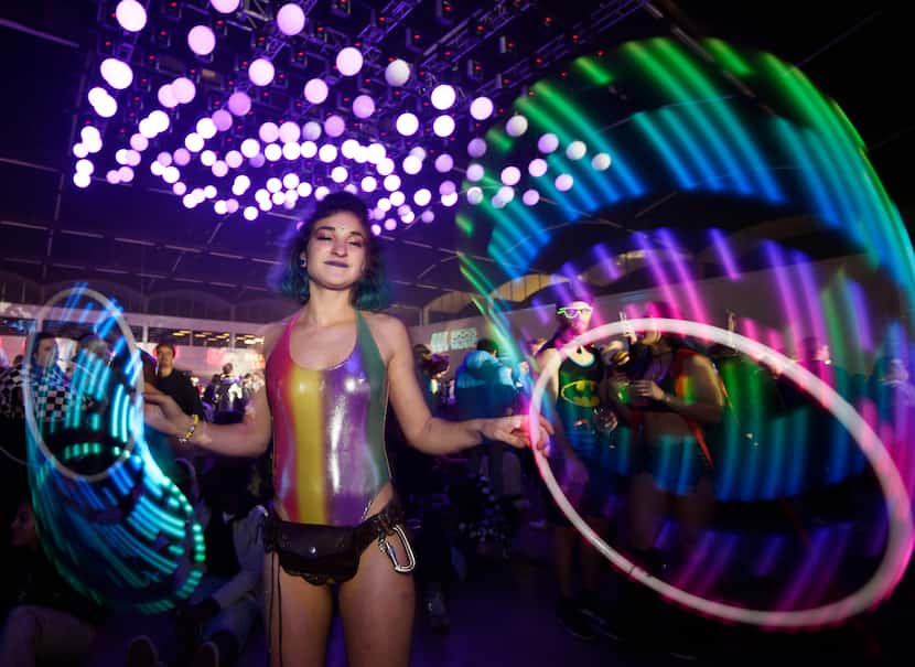 Rachel "Squeaky" McInerney, 25, of Chicago, dances with a pair of hula hoops during the...