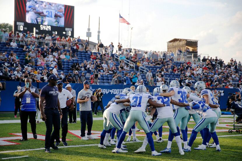 Former Dallas Cowboys player Michael Irvin watches as the Dallas Cowboys defense huddles...