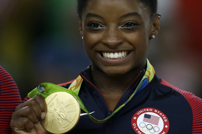 United States' Simone Biles displays her gold medal for floor during the artistic gymnastics...
