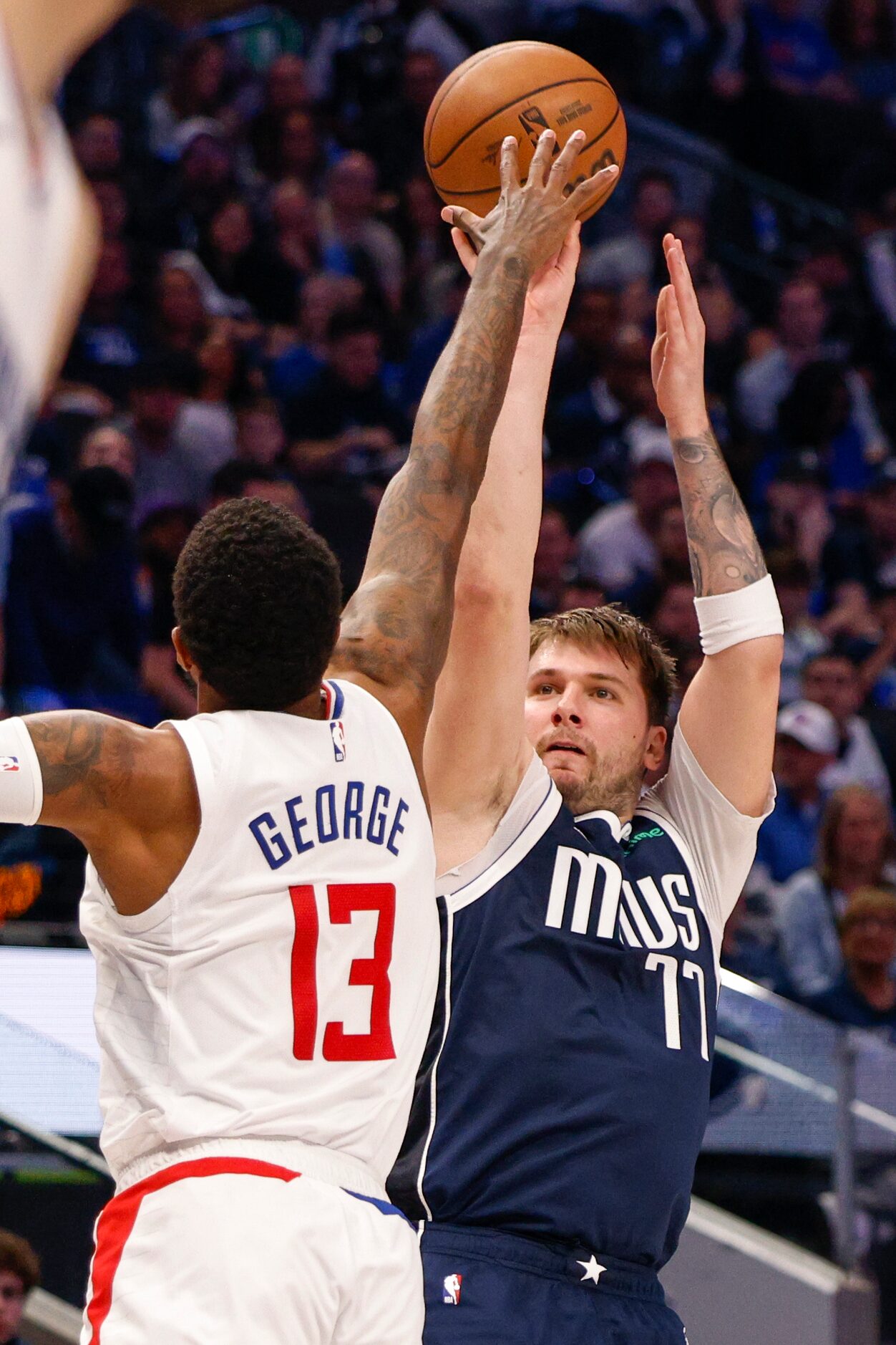 Dallas Mavericks guard Luka Doncic (77) shoots over LA Clippers forward Paul George (13)...