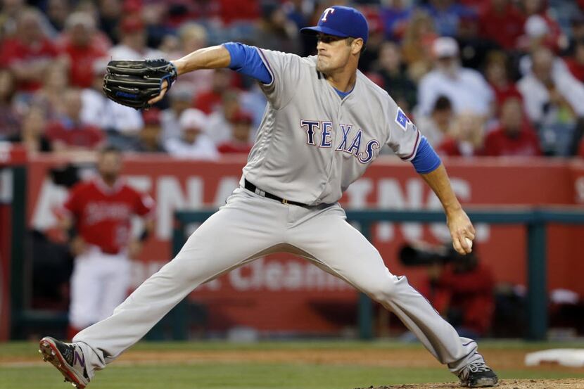 Texas Rangers' Cole Hamels delivers a pitch during the second inning of a baseball game...