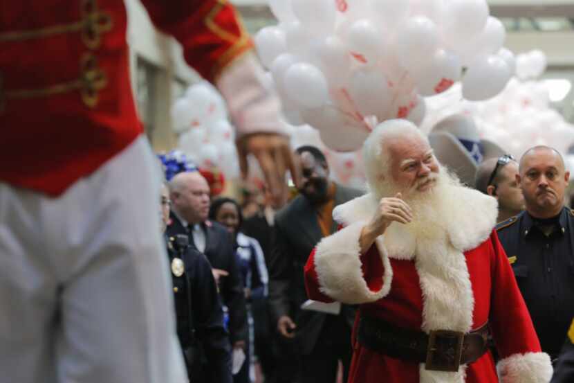 Santa Claus, a.k.a. Carl Anderson, waved to the crowd as a kickoff parade for the Salvation...