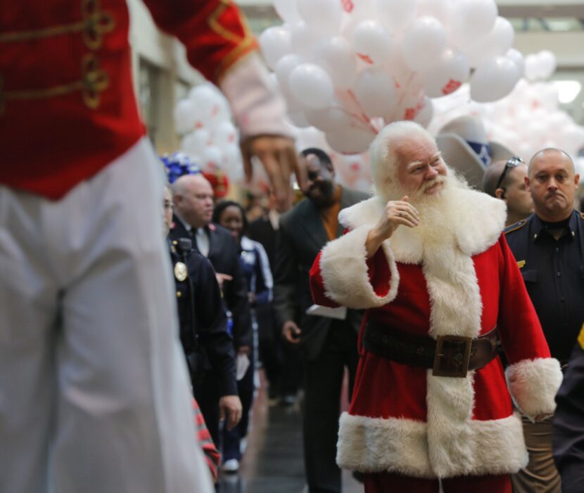 Santa Claus, a.k.a. Carl Anderson, waved to the crowd as a kickoff parade for the Salvation...