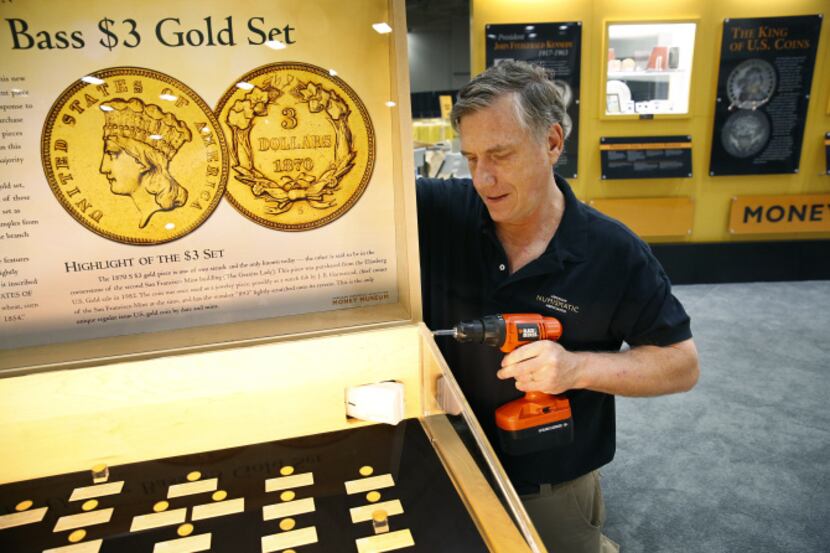 American Numismatic Association curator Doug Mudd constructs the case holding the Bass $3...