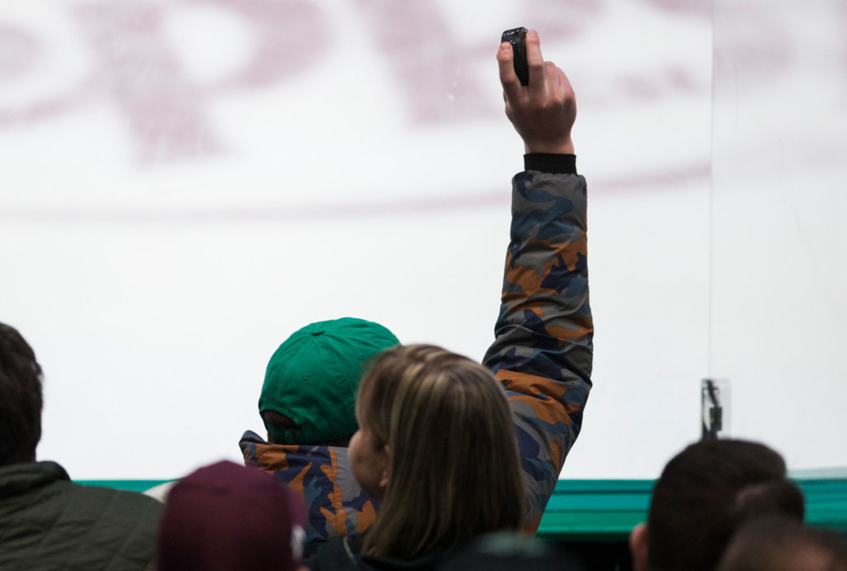 A fan holds up a puck that was deflected off the glass during the first period of an NHL...