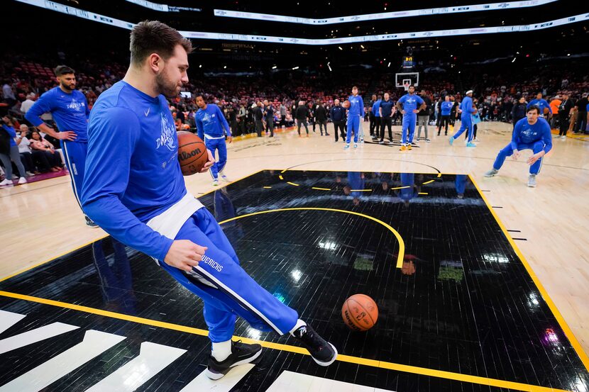 Dallas Mavericks guard Luka Doncic kicks a ball toward center Boban Marjanovic as the team...