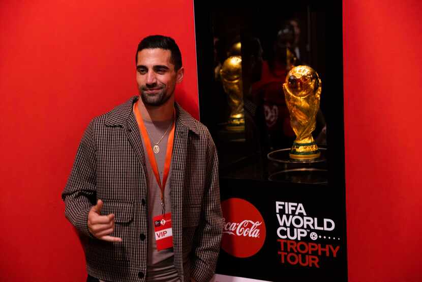 FC Dallas midfielder Sebastian Lletget poses next to the FIFA World Cup trophy on display...