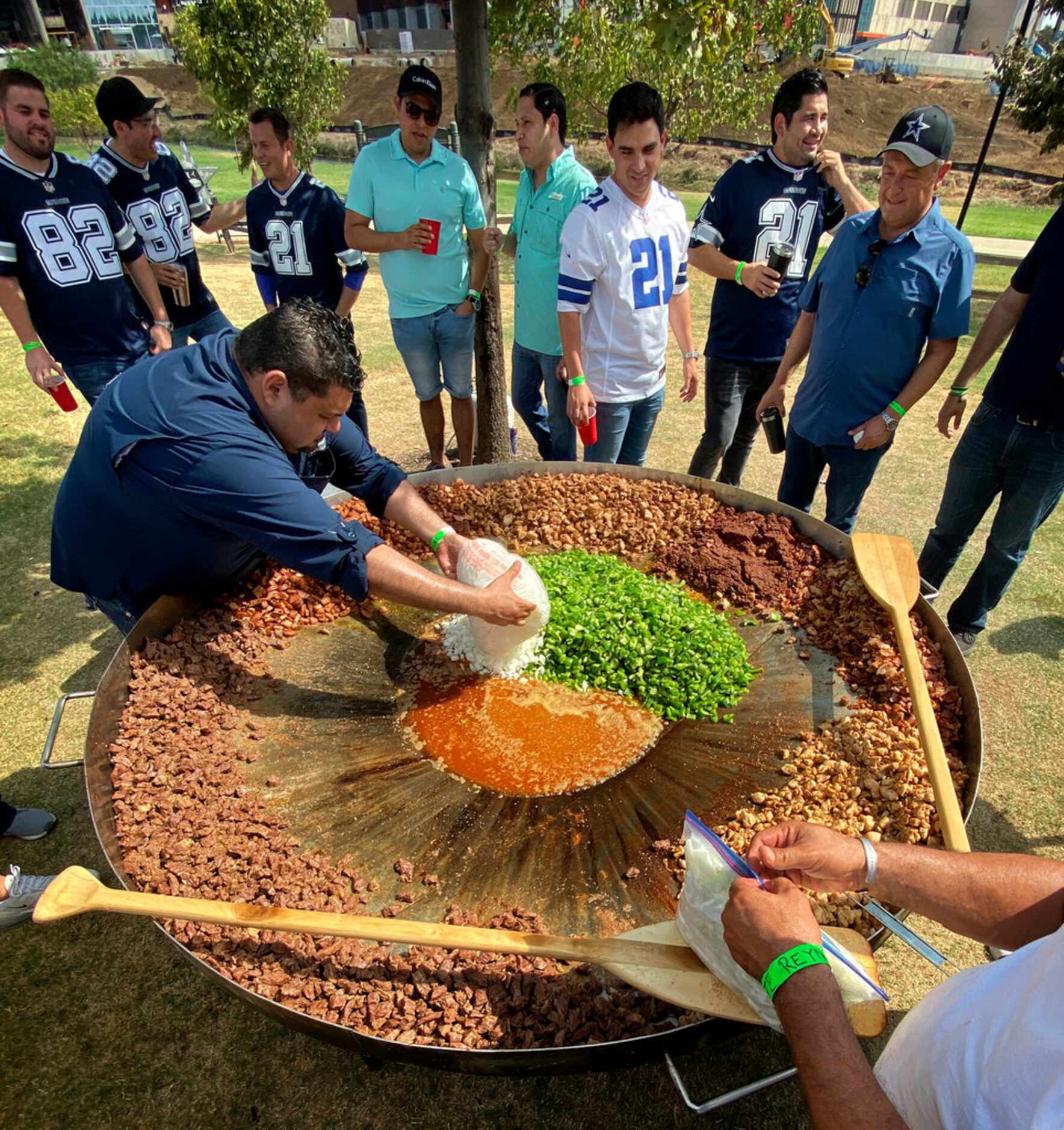 Dallas Cowboys fans prepare a discada, a mixed Mexican meat dish, during a tailgate party...