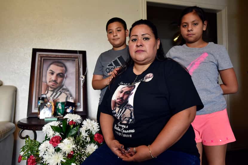 Vanessa Olguín with her children, Jorge, 12, and Amy, 10, pose with a portrait of her...