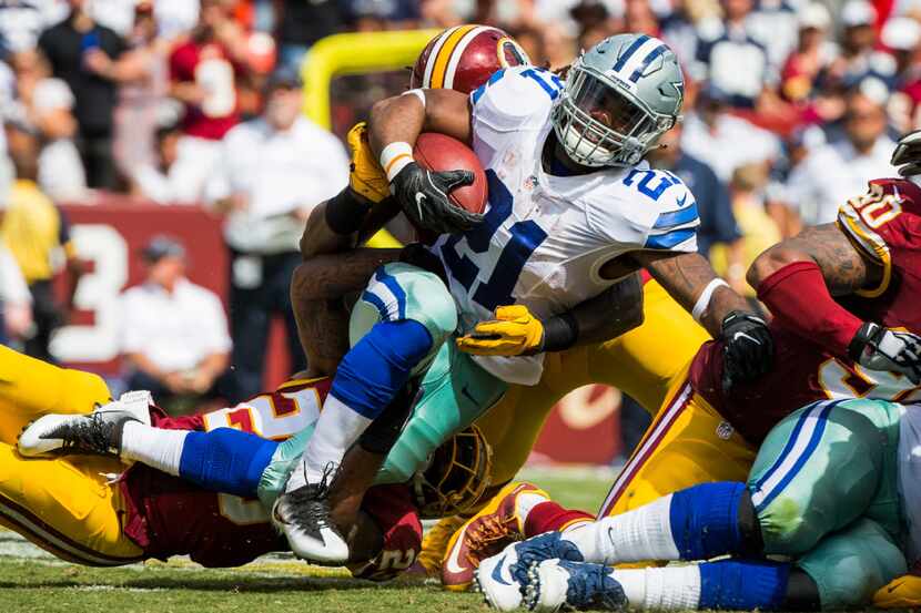 Dallas Cowboys running back Ezekiel Elliott (21) is brought down by Washington Redskins free...