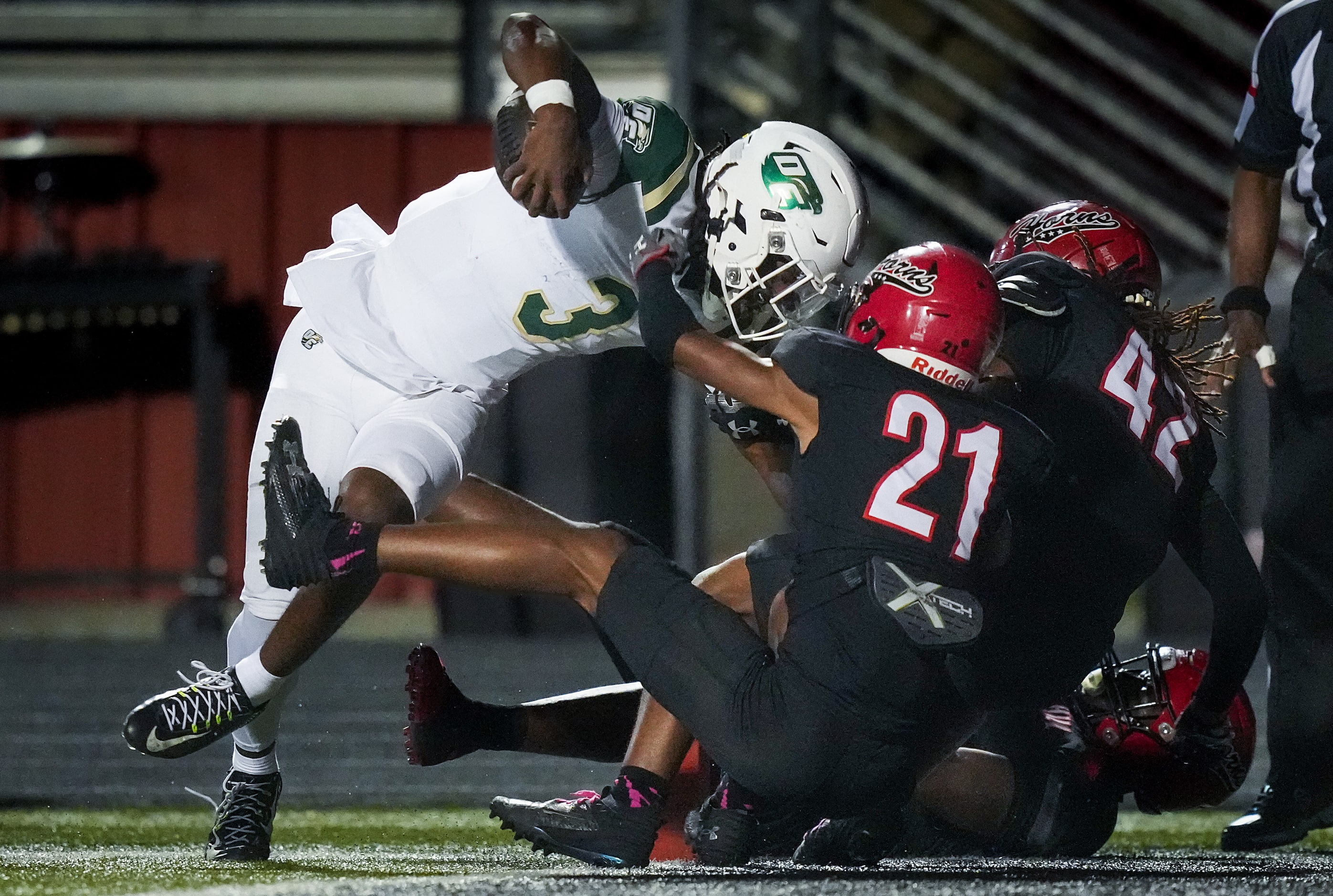 DeSoto quarterback Kelden Ryan (3) pushes into the end zone past Cedar Hill defensive backs...