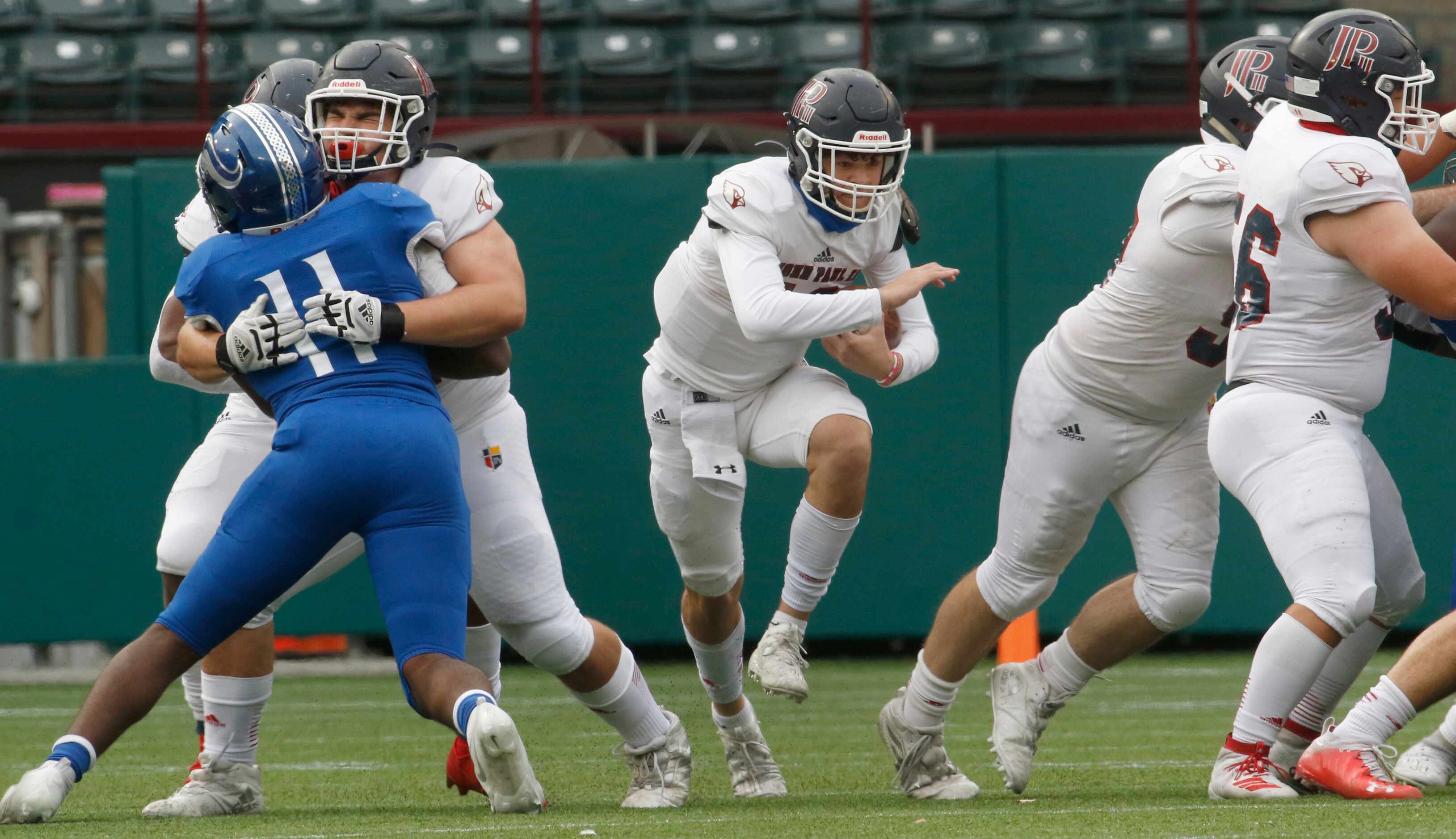 Plano John Paul ll quarterback Drew Forker (12) finds running room behind his front line...