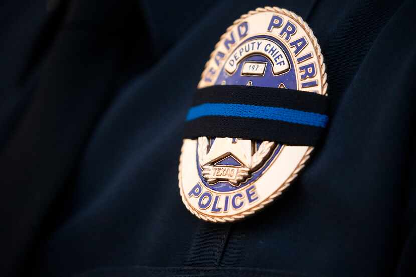 A Grand Prairie police deputy chief's badge is covered with a mourning band in honor of...