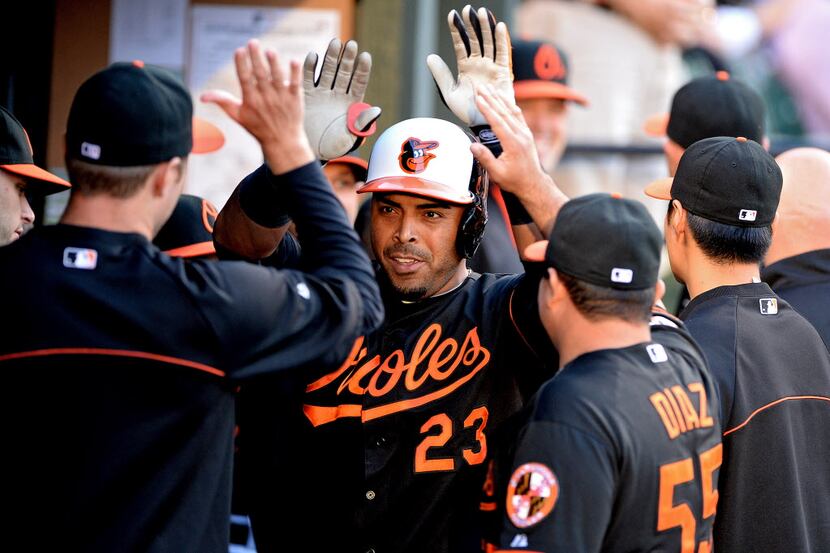 Nelson Cruz #23 of the Baltimore Orioles celebrates with teammates in the dugout after...