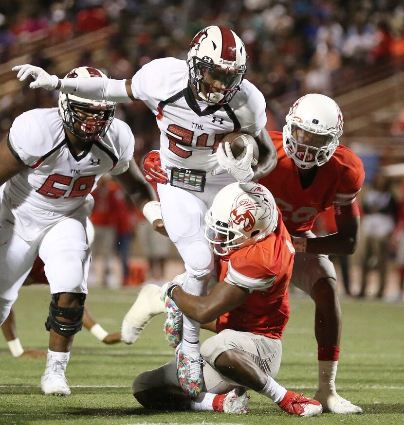 Cedar Hill running back Cameron Fleming (24) is tackled by Duncanville player Tre Siggers...