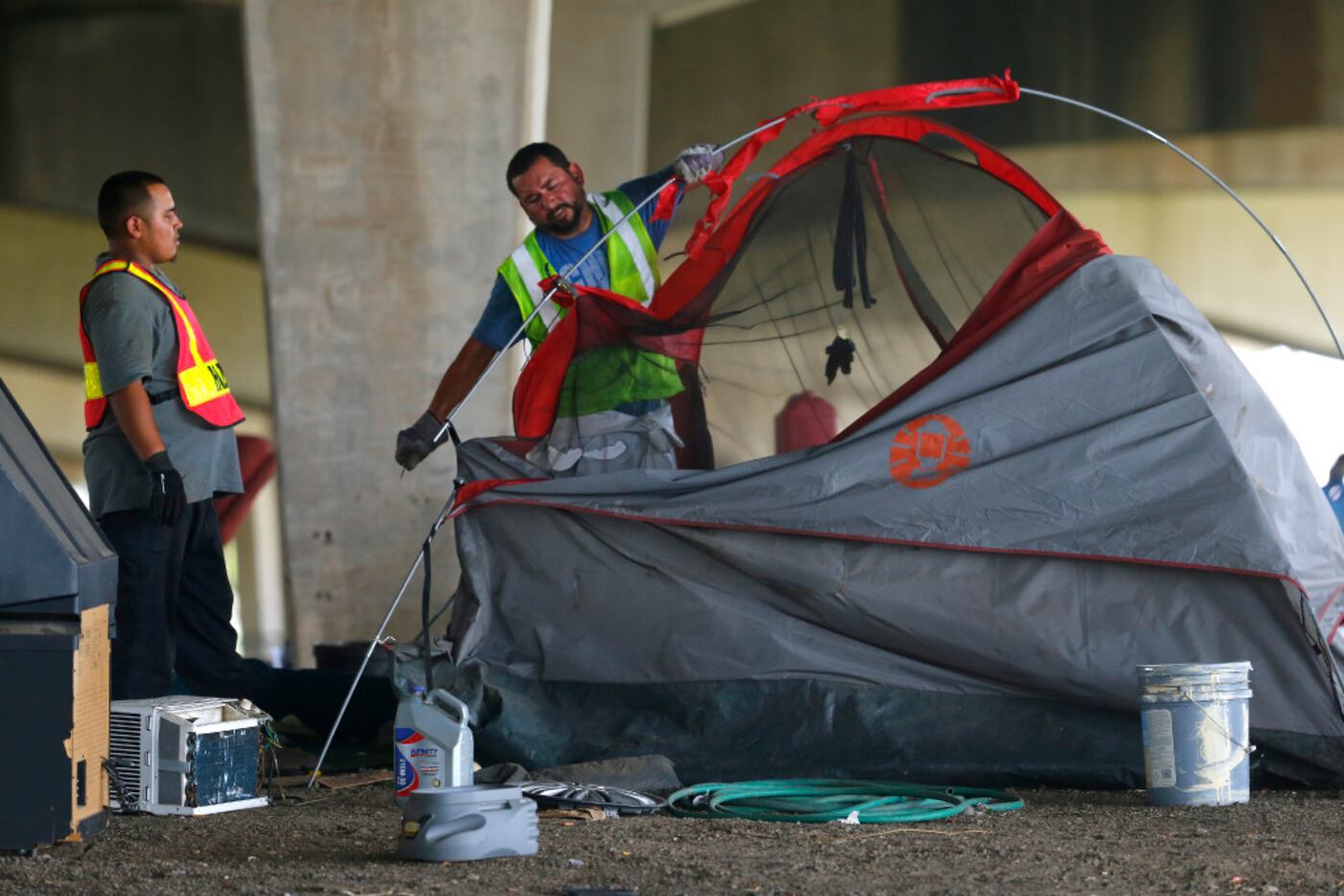 Hazardous material workers rip up a tent after the city closed a large homeless encampment...