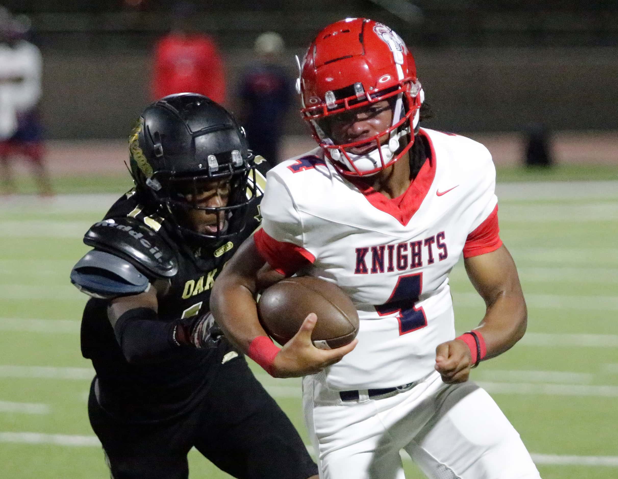 Kimball High School quarterback Armirie Williams-Hall (4) is chased by South Oak Cliff High...