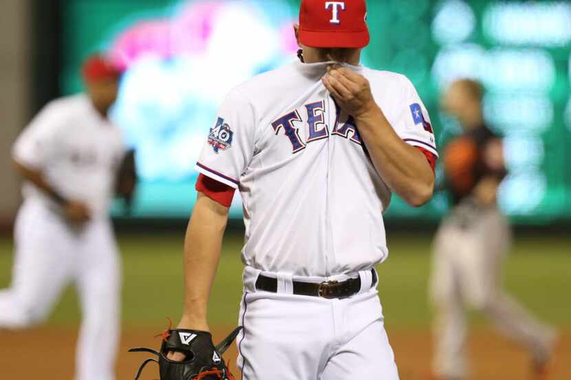 Texas Rangers starting pitcher Derek Holland (45) leaves the mound after getting the last...