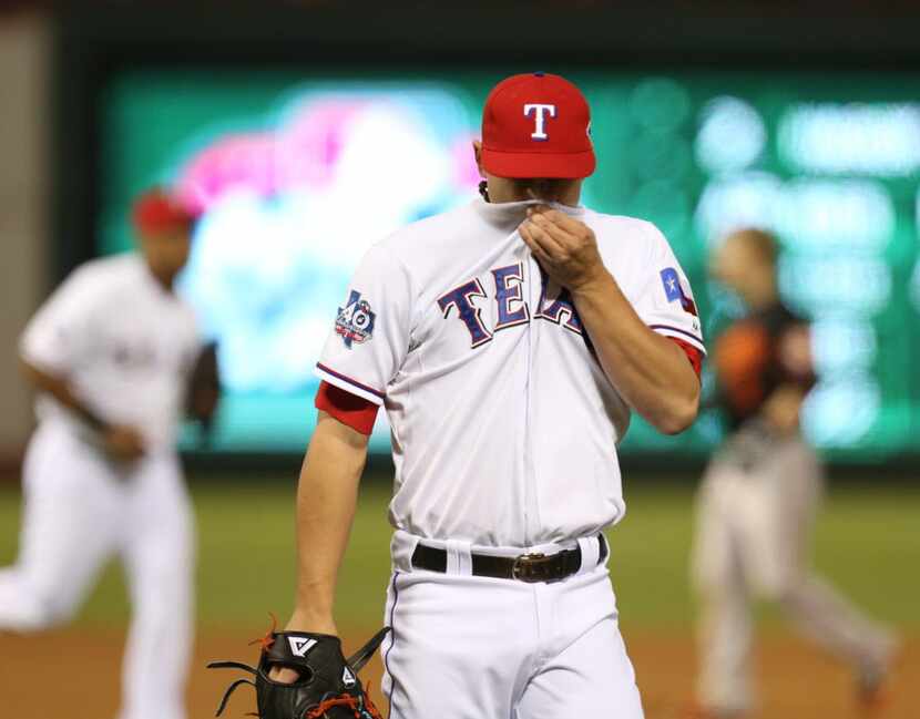 Texas Rangers starting pitcher Derek Holland (45) leaves the mound after getting the last...