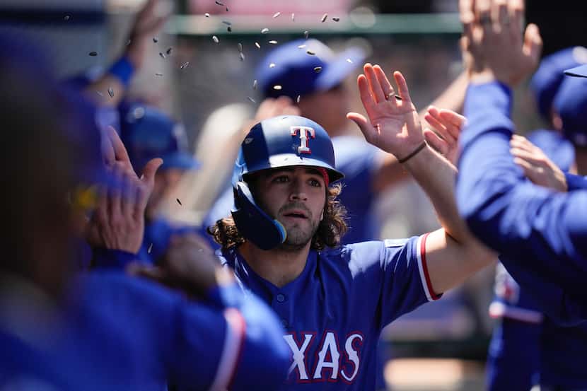 Texas Rangers' Josh Smith (47) celebrates in the dugout after hitting a home run during the...