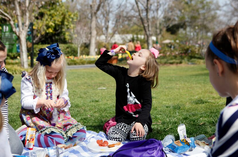 Jules Patterson, 5, left, and Emerson Dell, 7, both of Plano, sit with friends during a...