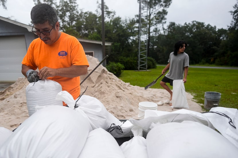 Jose Gonzales and his son Jadin Gonzales, 14, filled sand bags ahead of Hurricane Helene...