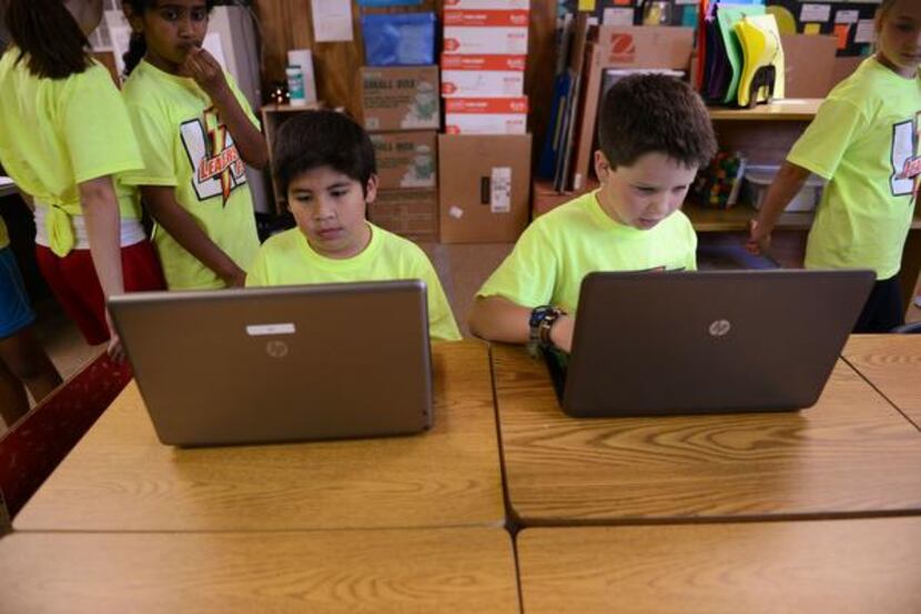 
Fourth-grade students Cristian Cavazos (left) and Brooks Johnson work on an assignment. 
