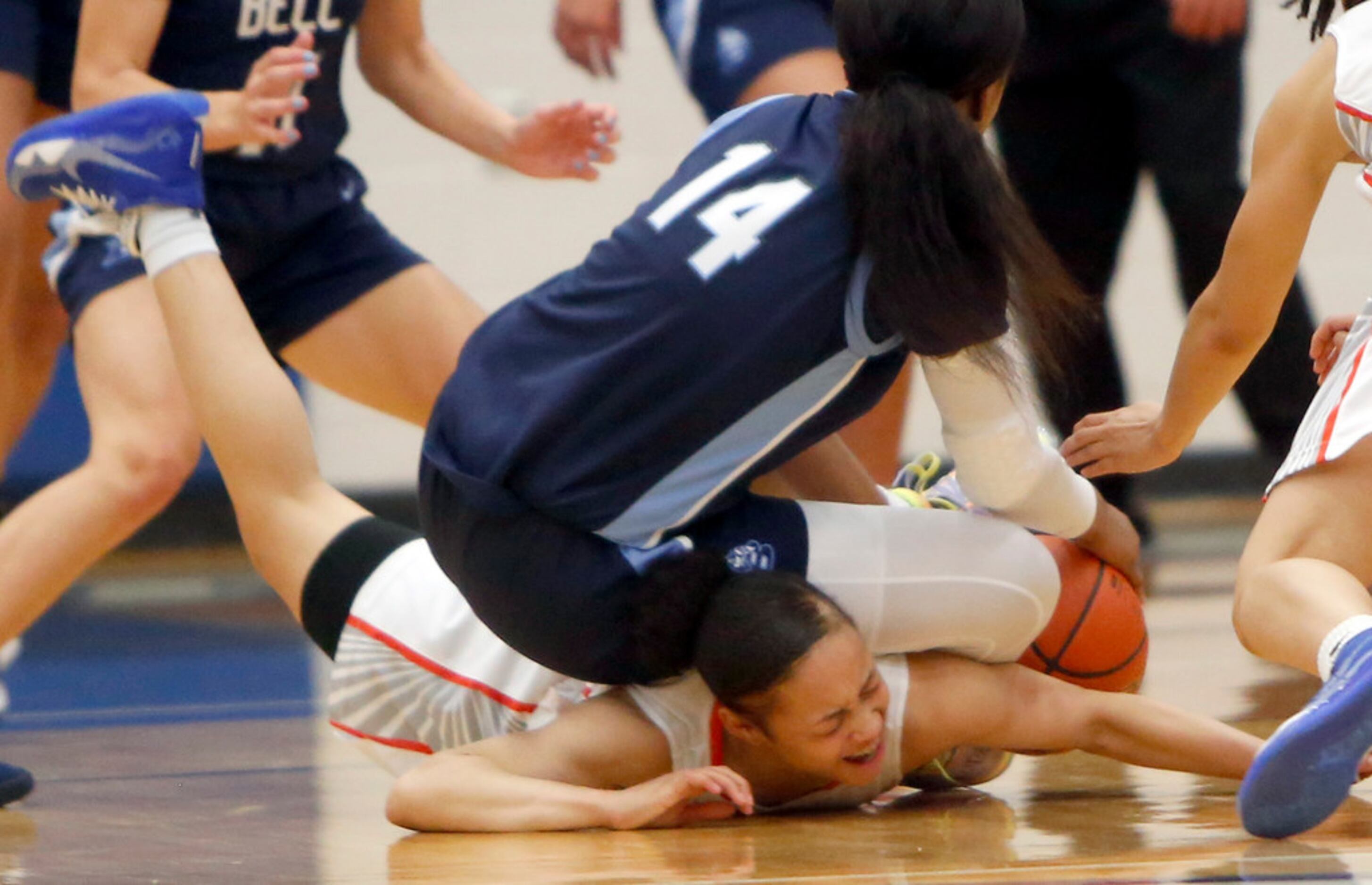 Arlington Bowie guard Alexis Smith (4) winces in pain as she tumbles with Hurst L.D. Bell...