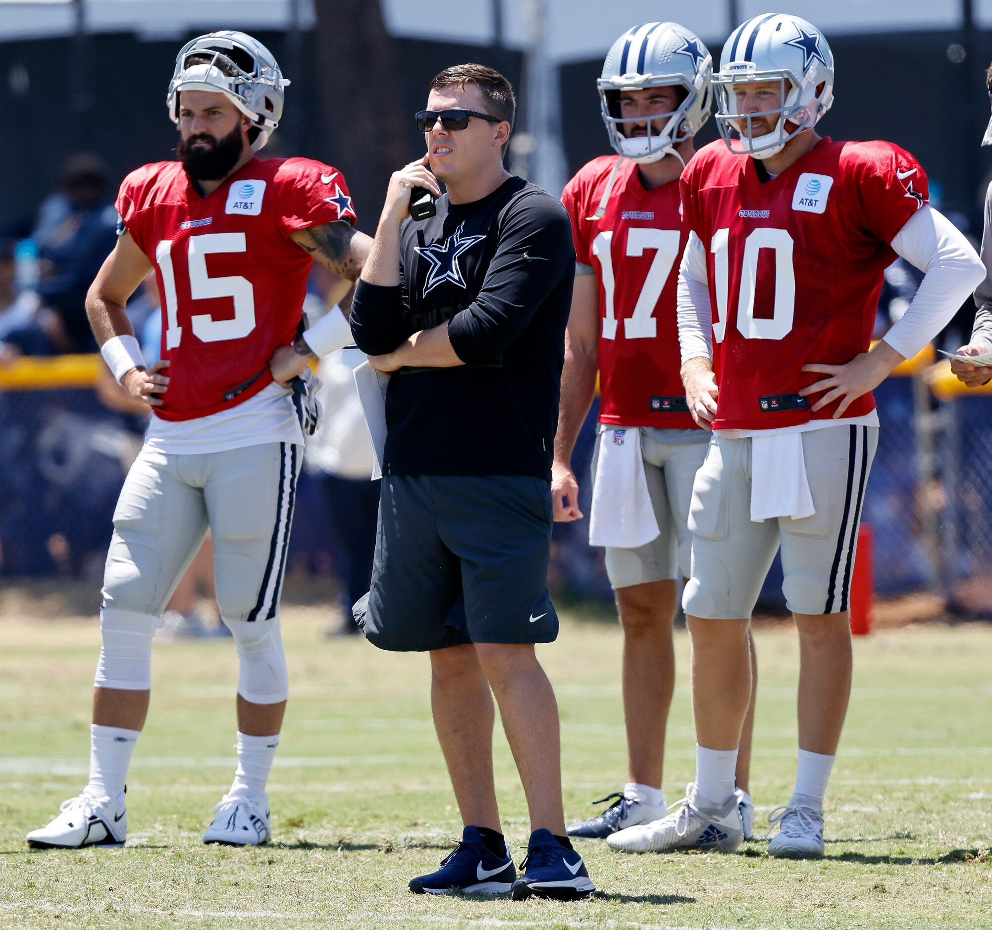 Dallas Cowboys offensive coordinator Kellen Moore and the backup quarterbacks watch starting...