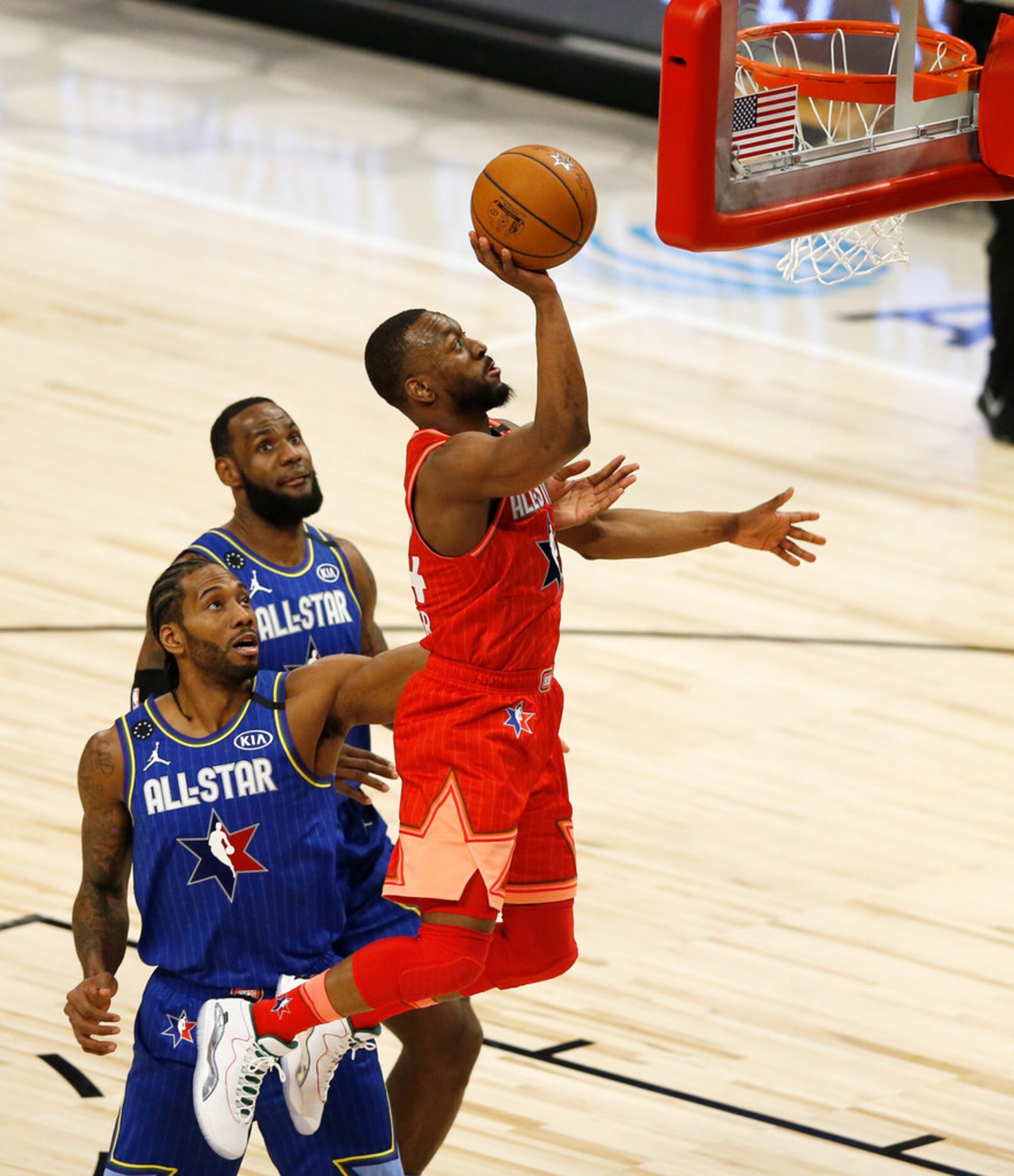 Team Giannis' Kemba Walker (24) attempts a layup in front of Team LeBron's Kawhi Leonard (2)...