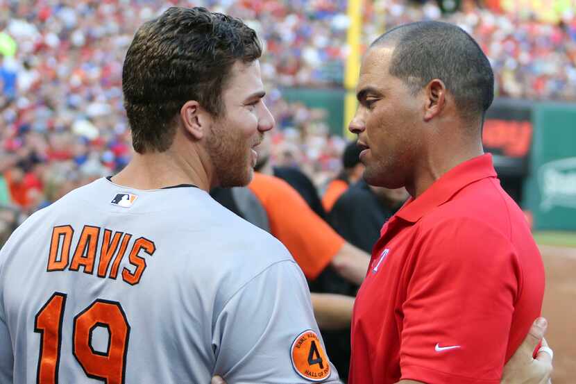 Former Texas catcher Ivan "Pudge" Rodriguez visits with Baltimore's Chris Davis at Rangers...